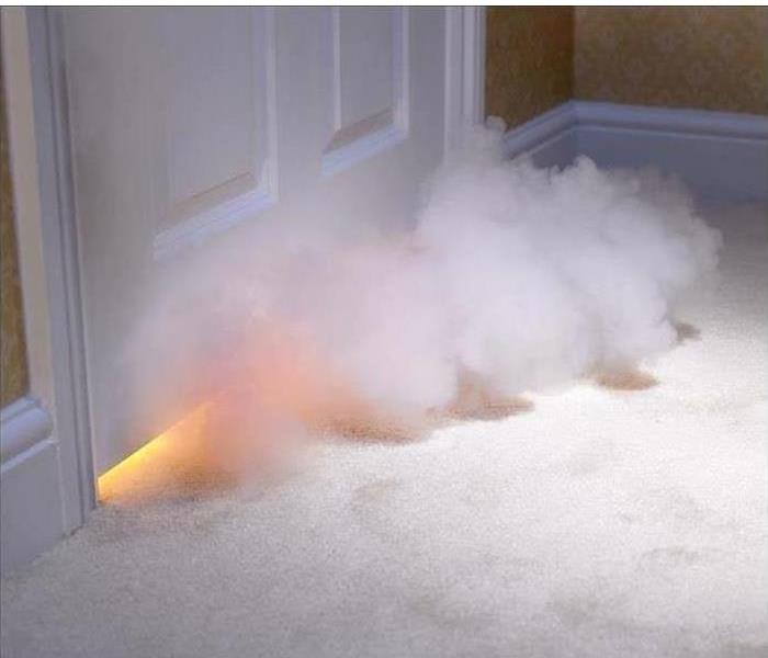 We can help when you experience a house fire - image of smoke coming from under door